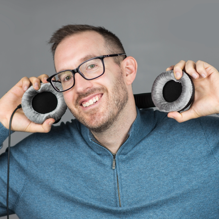Color photograph of Matthew Fecher putting a set of headphones around his head