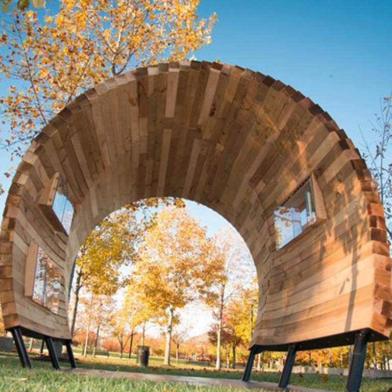 An arched sculpture made out of wood in an Indianapolis park also allows people a space to share books.