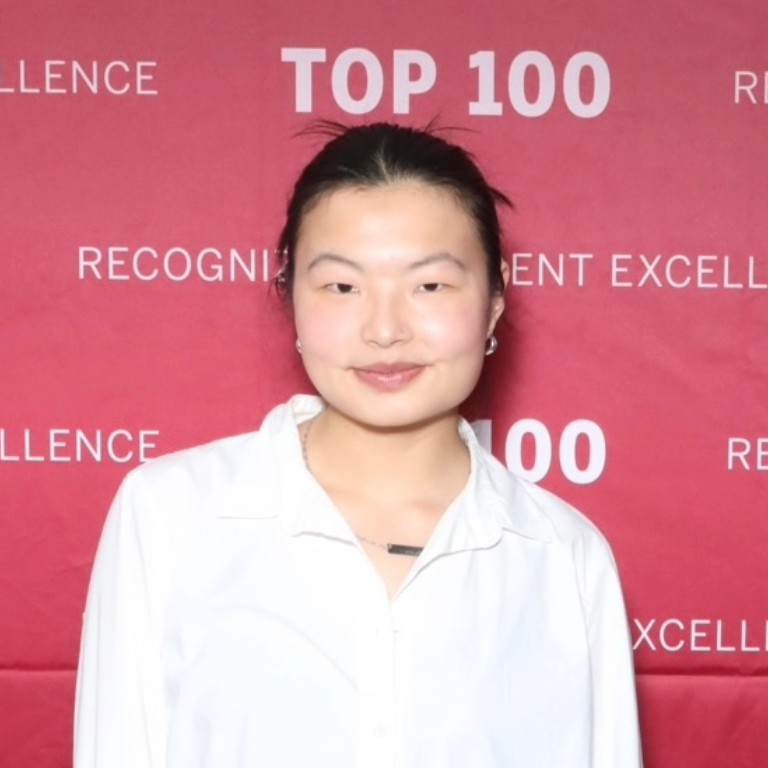 Herron student Min Durham smiling in front of a banner that says IU Indianapolis Top 100
